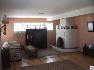 1400 Manzanita living room with original hardwood floors, stained glass, and wood burning fireplace. 